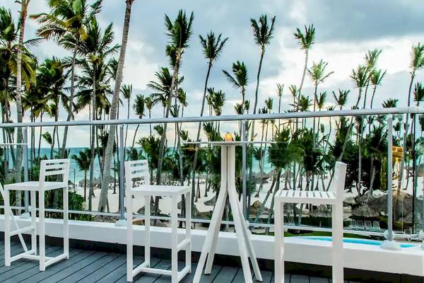 Terrasse des Melia Caribe Beach Resort mit Blick auf den Ozean und weiße Stühle