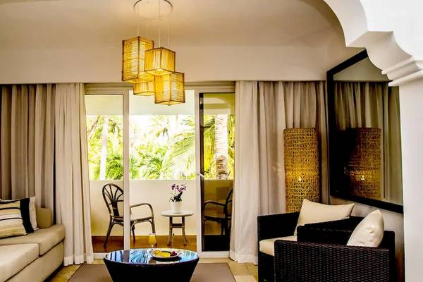 Wohnbereich des Melia Caribe Beach Resort mit Couch, Tisch und Glastüren.