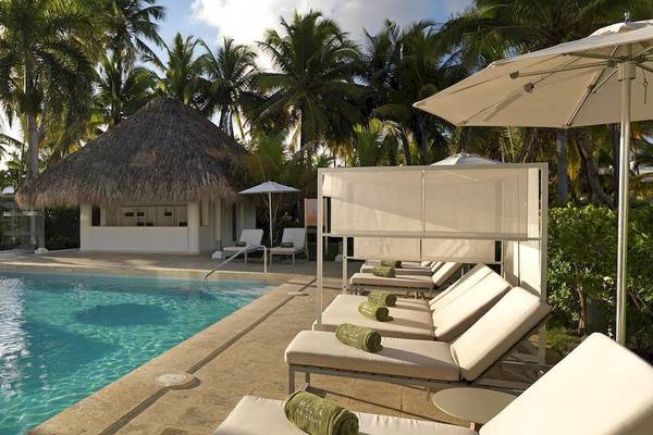 Pool-Lounge-Bereich im Melia Caribe Beach Resort mit Sonnenliegen und Sonnenschirmen.