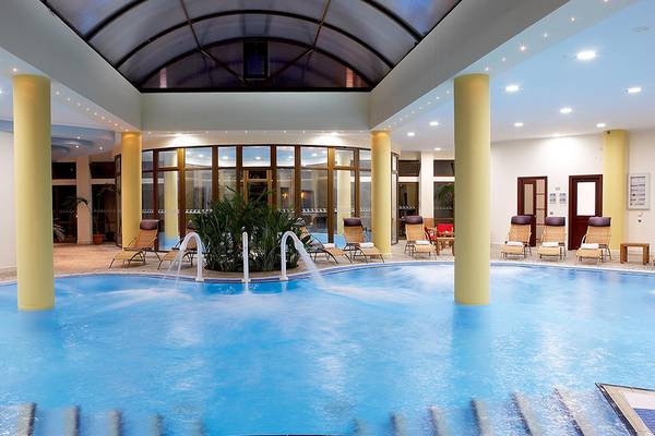 Innenpool des Atrium Palace Thalasso Spa Resort & Villas mit Wasserfällen und Sonnenliegen