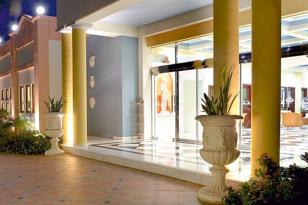 Der Eingang des Atrium Palace Thalasso Spa Resort & Villas mit Säulen und Pflanzen in großen Vasen.