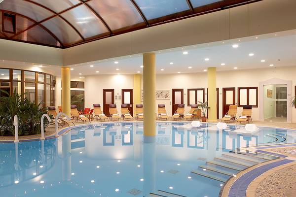 Innenpool des Atrium Palace Thalasso Spa Resort & Villas mit Lounge-Liegen und Pflanzen