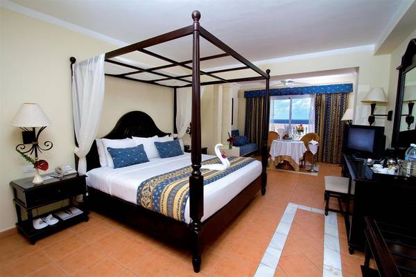 Schlafzimmer im Bahia Principe Grand Jamaica mit Himmelbett, Aussicht auf den Balkon und Meer