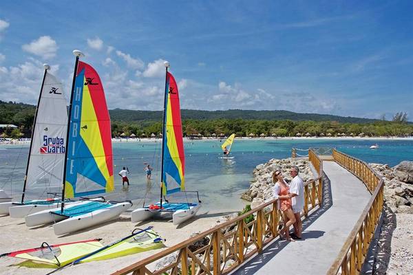 Paare am Strand des Bahia Principe Grand Jamaica, Katamarane im Hintergrund.