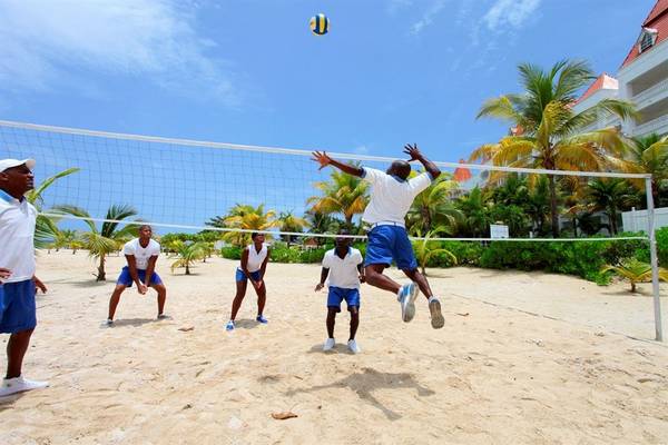 Spieler spielen Beachvolleyball am Strand vor dem Bahia Principe Grand Jamaica Hotel