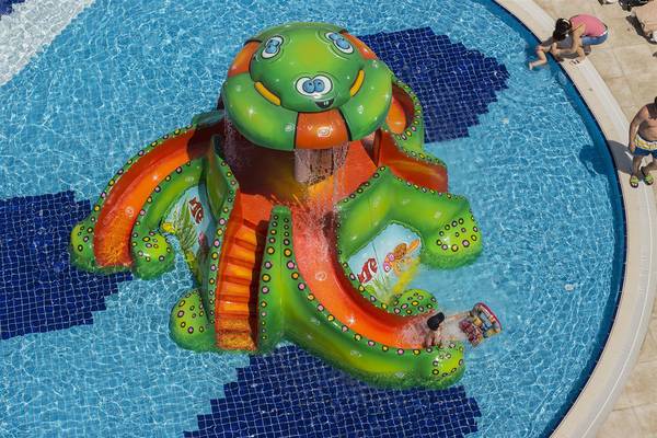 Ein großer, grüner und orangefarbener Wasserturm mit einer Wasserrutsche im Schwimmbad des Dream World Aqua Hotels.
