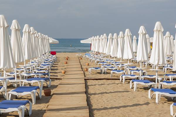 Strand mit vielen weißen Sonnenschirmen und blauen Liegestühlen im Dream World Aqua Hotel.