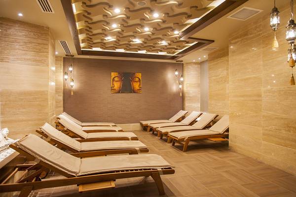 Relaxationsraum im Dream World Aqua Hotel mit cremefarbenen Liegen und einem Bild von Buddha.