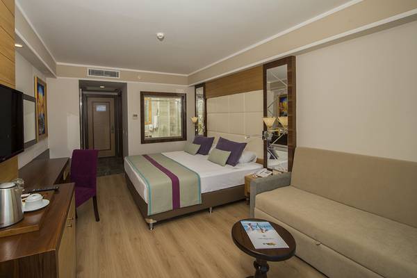 Zimmer im Dream World Aqua Hotel mit Bett, Fernseher, Schreibtisch und Sofa.