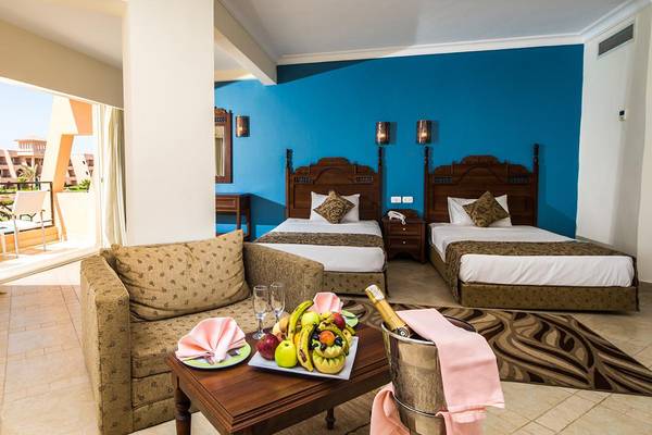 Suite mit Balkon im Jasmine Palace Resort & Spa mit zwei Betten, Wohnzimmer, Obstplatte und Flasche Champagner.