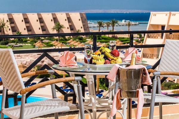 Balkon mit Tisch im Jasmine Palace Resort & Spa mit Blick auf den Pool und das Meer.