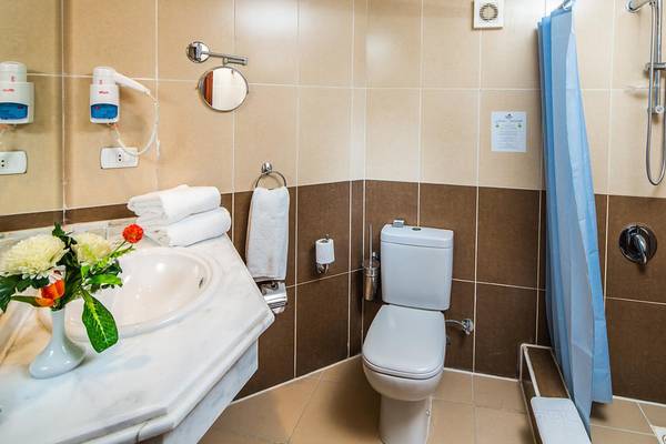 Badezimmer im Jasmine Palace Resort & Spa mit weißem Waschbecken, Toilette, Handtüchern und Dusche.
