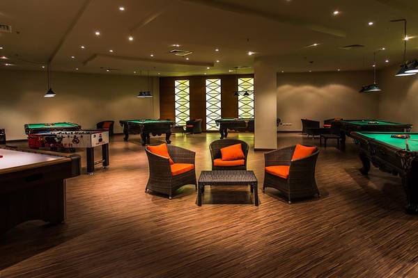 Spielzimmer im Jasmine Palace Resort & Spa mit Billardtischen, Tischfußball und Sitzmöbeln.