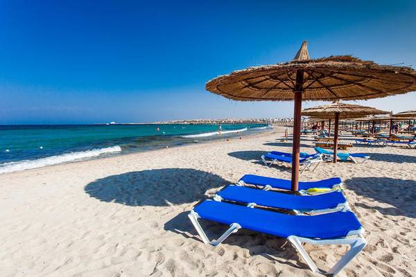 Strand mit blauen Sonnenliegen und Sonnenschirmen am Jasmine Palace Resort & Spa