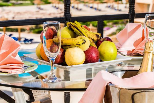 Obstplatte auf der Terrasse im Jasmine Palace Resort & Spa mit verschiedenen Früchten, Gläsern und Flaschen.