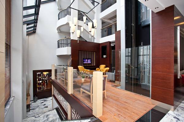 Innenansicht der Lobby des Cettia Beach Resorts mit Glasbalkon, Sofas und Fernseher.