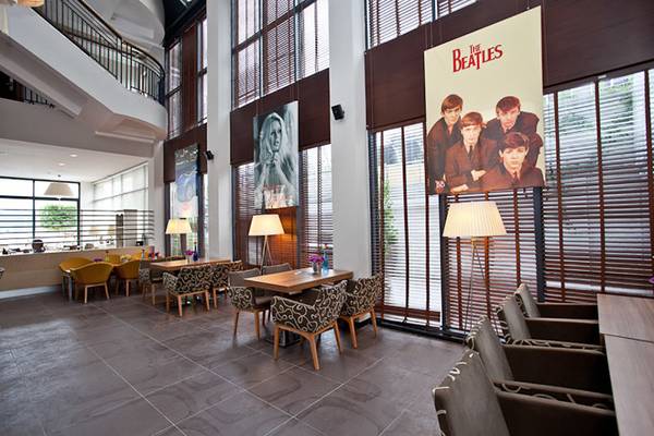 Loungebereich im Cettia Beach Resort Hotel mit Beatles-Poster und modernen Möbeln.