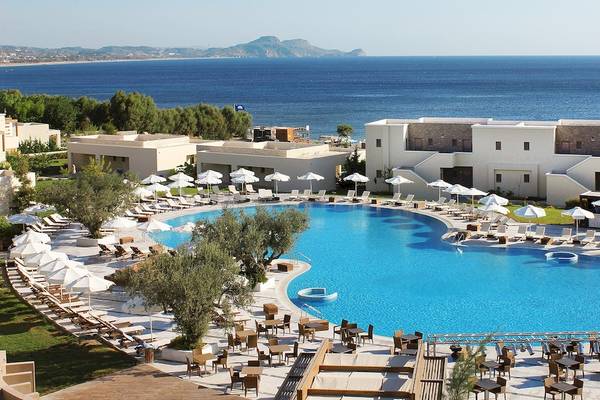 Außenbereich des Sentido Port Royal Villas & Spa mit großem Pool, Sonnenliegen und Schirmen.