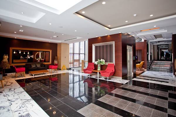 Lobby des Cettia Beach Resorts mit schwarzen und weißen Fliesen und roten Stühlen.