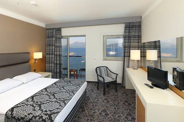 Bettzimmer im Cettia Beach Resort mit Meerblick, modernem Design und bequemen Möbeln.