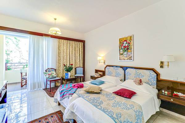 Doppelzimmer im Creta Royal Hotel mit zwei Betten, Dekor und Balkonansicht.