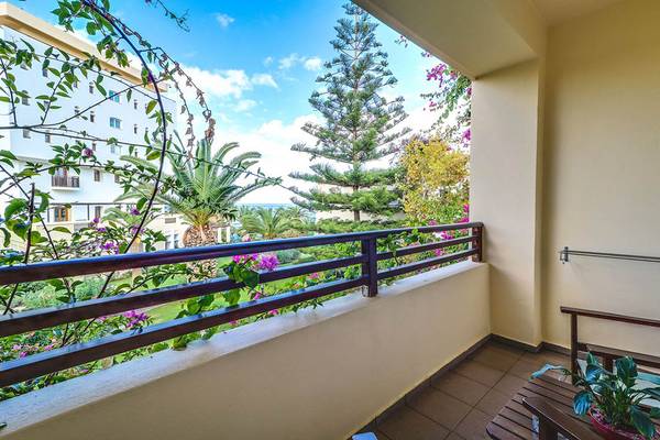 Ausblick vom Balkon des Creta Royal - Adults Only Hotels auf einen Garten und eine Straße.