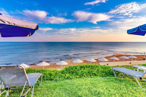 Strandblick vom Creta Royal Hotel mit Liegen und Sonnenschirmen