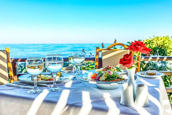 Gedeckter Tisch im Freien mit Blick auf das Meer im Creta Royal Hotel.