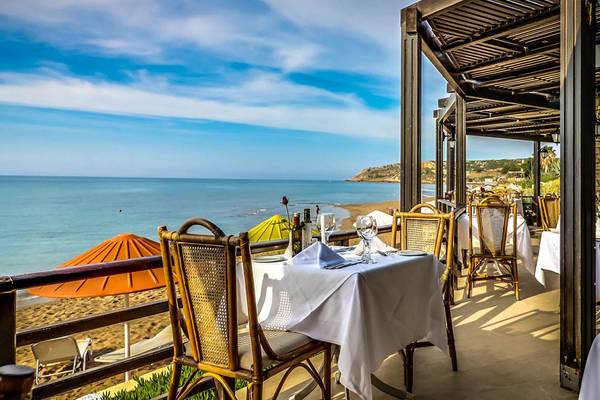 Außenterrasse des Creta Royal - Adults Only Hotels mit Blick auf das Meer und einen bewölkten Himmel.