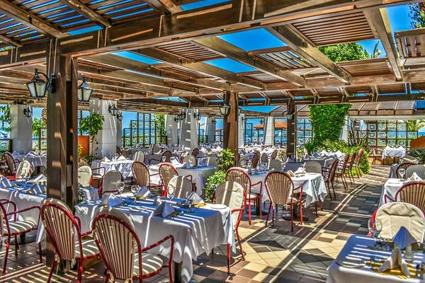 Foto einer Terrassen-Restaurant im Creta Royal Hotel mit Holzüberdachung und Blick auf die Stadt.