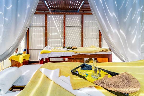 Spa Bereich im Creta Royal Hotel mit Behandlungsliegen, gelben Handtüchern und Massageutensilien.
