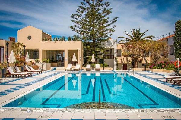 Poolbereich des Creta Royal - Adults Only Hotels mit Lounge-Liegen und Palmen