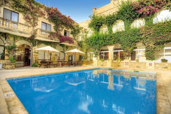 Außenbereich des Cornucopia Bungalows Hotels mit Swimmingpool und terrassenartigem Eingang.