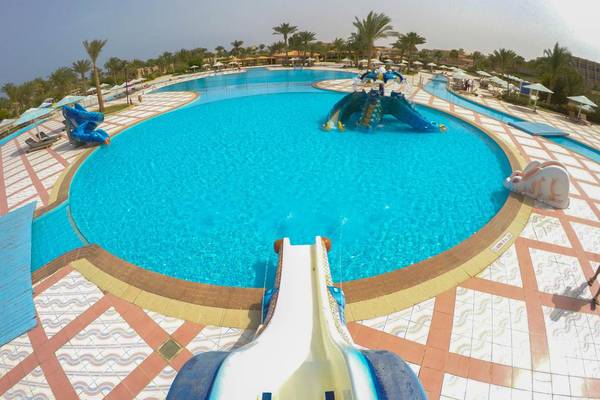 Luftaufnahme des Swimmingpools im Pharaoh Azur Resort mit Wasserrutschen und Sonnenschirmen.