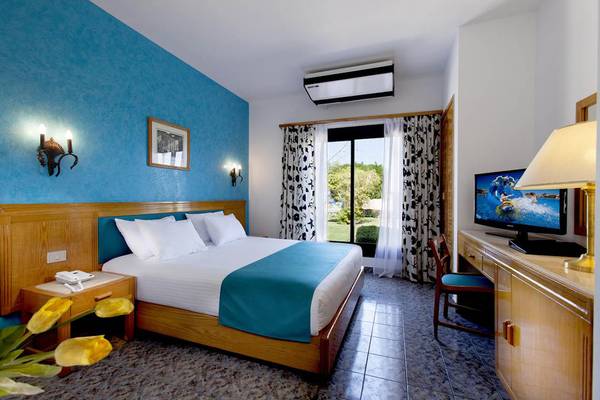 Hotelzimmer im Pharaoh Azur Resort mit blauen Wänden, Doppelbett, Fernseher und Schreibtisch.
