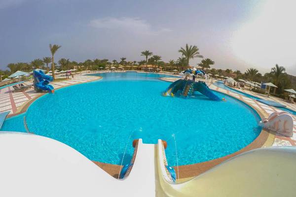 Luftaufnahme des Schwimmbeckens im Pharaoh Azur Resort mit Wasserrutschen und Palmen im Hintergrund.