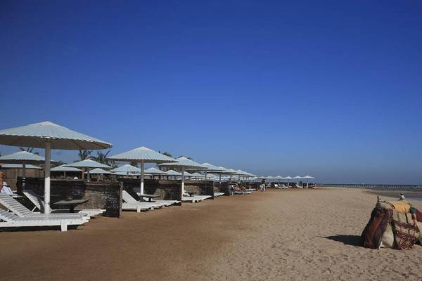 Strand mit Sonnenschirmen, Liegestühlen und Kamel am Pharaoh Azur Resort