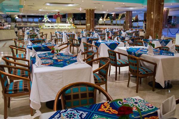 Innenbereich des Restaurants im Pharaoh Azur Resort mit gedeckten Tischen und blau-weißen Tischdecken.