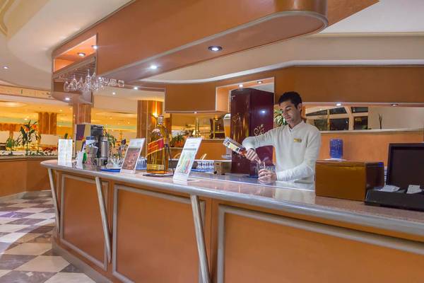 Ein Barkeeper im Pharaoh Azur Resort schenkt ein Getränk in ein Glas ein.