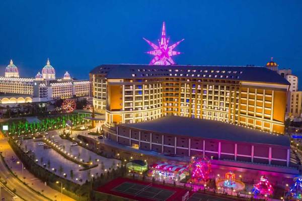 Luftaufnahme des Royal Seginus Hotels bei Nacht mit beleuchteter Fassade und Sternendekoration