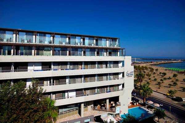 Außenansicht des Kriti Beach Hotels mit mehreren Stockwerken, Terrassen, Swimmingpool und Meer im Hintergrund.