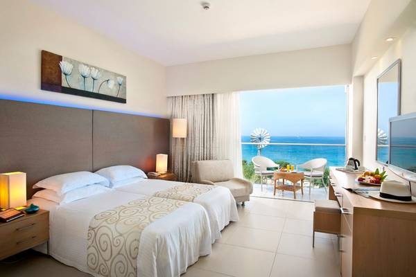 Zimmer im Pernera Beach Hotel mit Blick auf das Meer und eine Terrasse.