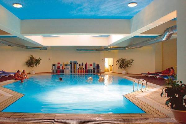 Innenpool des Pernera Beach Hotels mit mehreren Schwimmern und Lounge-Bereichen.