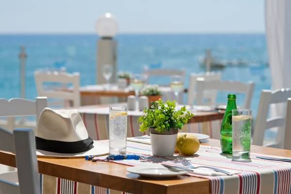 Terrasse des Pernera Beach Hotels mit Blick auf das Meer und einem gedeckten Tisch.