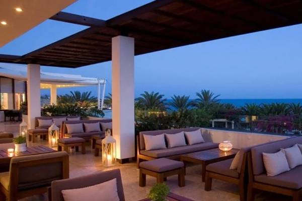 Außenbereich des Alion Beach Hotels mit Blick auf das Meer, Loungemöbel und Palmen
