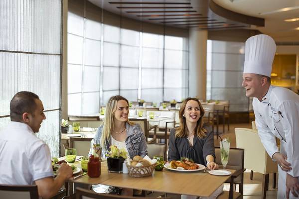 Glückliche Gäste, die im Restaurant des Jumeira Rotana Hotels essen.