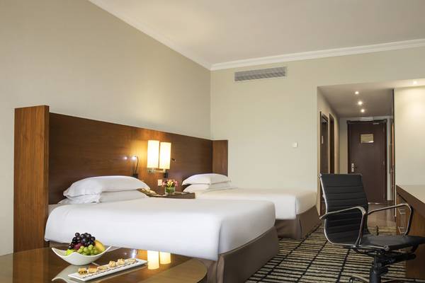 Doppelbett-Zimmer im Jumeira Rotana Hotel mit Früchtetablett und Schreibtisch.