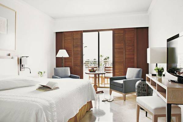 Schlafzimmer im Annabelle Resort mit Bett, Sesseln, Tisch und Fernseher