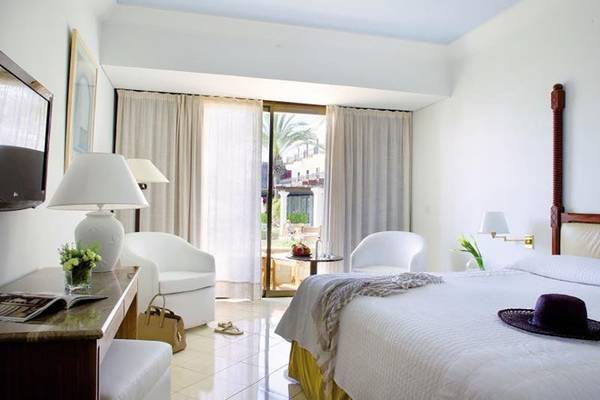 Annabelle Resort Hotelzimmer mit Bett, Schreibtisch, Stühlen und Terrassenansicht.