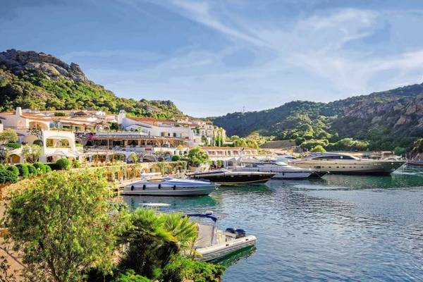 Außenansicht des Grand Hotel Poltu Quatu mit mehreren Booten in der Marina.